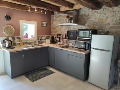 a kitchen with a white refrigerator and a microwave at Le clos de josephine in Peyregoux
