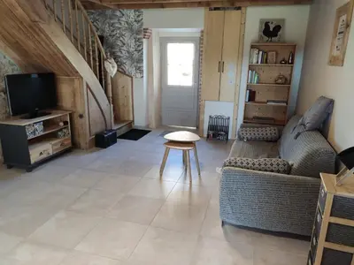 a living room with a couch and a tv at Le clos de josephine in Peyregoux