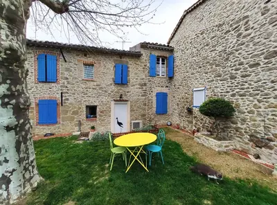 a table and chairs in front of a stone building at Le clos de josephine in Peyregoux