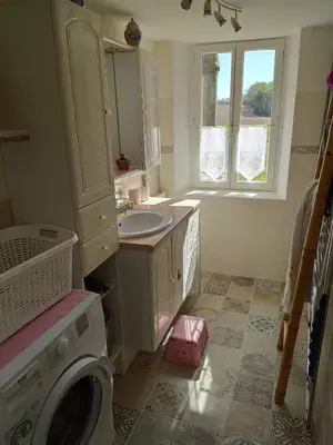 a bathroom with a sink and a washing machine at Le clos de josephine in Peyregoux