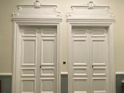 two white doors with ornate detailing on a wall at La Maison de L' Ambassadeur Carcassonne B&B in Carcassonne