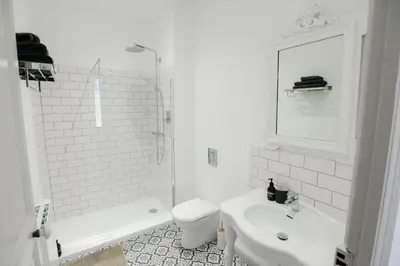 a white bathroom with a toilet and a sink at La Maison de L' Ambassadeur Carcassonne B&B in Carcassonne