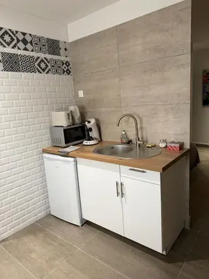 a kitchen with a sink and a microwave at L'atelier in Capestang