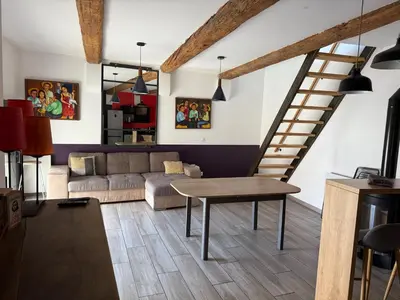a living room with a couch and a staircase at L'atelier in Capestang