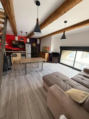 a living room with a couch and a table at L'atelier in Capestang