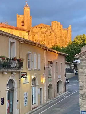a street with buildings and a castle in the background at L'atelier in Capestang