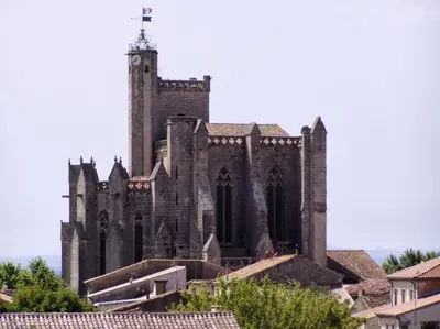 an old church with a tower on top of roofs at L'atelier in Capestang