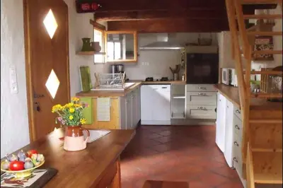 a kitchen with white appliances and a wooden counter top at Charmant Mas tout équipé en pleine nature catalane in Cases-de-Pène
