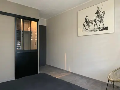 a room with a black door and a picture of horses on the wall at Sur la Terrasse in Sigean