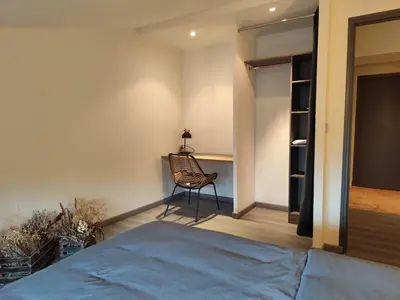 a bedroom with a bed and a chair in it at Sur la Terrasse in Sigean