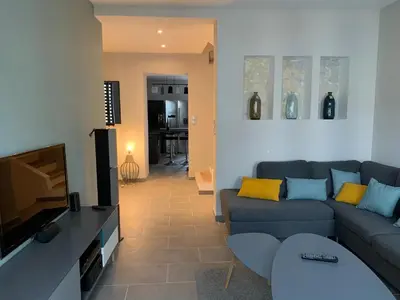 a living room with a couch and a flat screen tv at Sur la Terrasse in Sigean