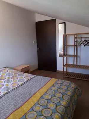 a bedroom with a bed and a ladder and a door at La Sigeannaise maison climatisée Wi-Fi in Sigean
