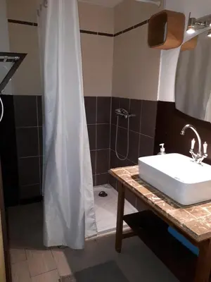 a bathroom with a white sink and a shower at La Sigeannaise maison climatisée Wi-Fi in Sigean