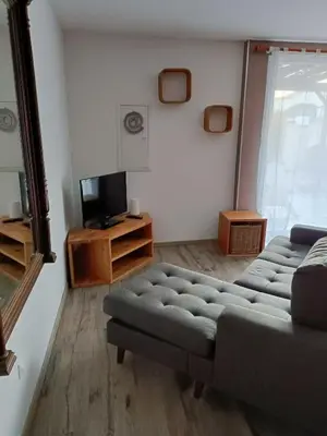 a living room with a couch and a tv at La Sigeannaise maison climatisée Wi-Fi in Sigean