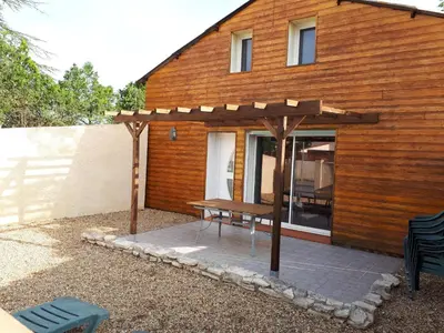 a picnic table in front of a wooden house at La Sigeannaise maison climatisée Wi-Fi in Sigean