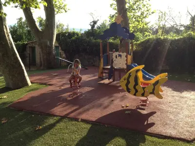a little girl is playing on a playground at RIBES - Chalet Gîte au coeur de la nature in Sournia