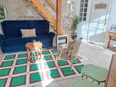 a room with chairs and a table and a counter at Le gîte de Sainte Valière PISCINE,SPA et CLIMATISATION in Sainte-Vallière
