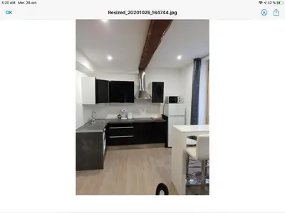 a kitchen with black and white cabinets and a table at Appartement Plein centre in Narbonne