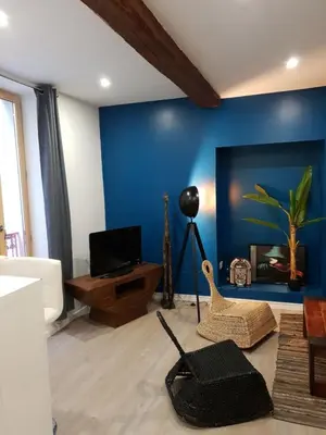 a living room with a blue wall and a table at Appartement Plein centre in Narbonne
