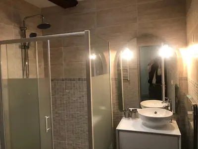a bathroom with a shower and a sink and a mirror at Appartement Plein centre in Narbonne