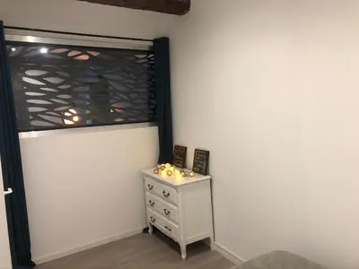 a bedroom with a dresser and a window at Appartement Plein centre in Narbonne