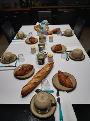 a table with plates of food and bread on it at Chambres d'hôtes Natacha et Franck in Labastide-Rouairoux
