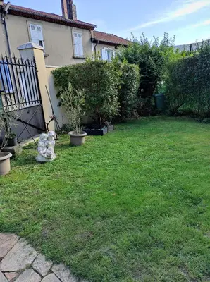 a teddy bear sitting in the yard of a house at Chambres d'hôtes Natacha et Franck in Labastide-Rouairoux