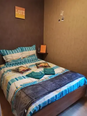 a bed with a comforter on it in a bedroom at Chambres d'hôtes Natacha et Franck in Labastide-Rouairoux