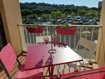 a table with a glass of wine on a balcony at Entre port et village in Gruissan
