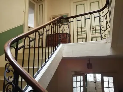 a staircase in a house with a wooden railing at MAISON ALBA LA SOURCE in Mazamet