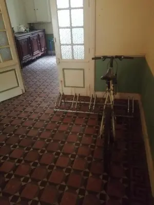a bike parked in a room with a checkered floor at MAISON ALBA LA SOURCE in Mazamet