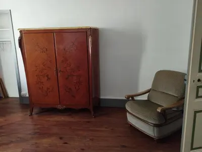 a wooden cabinet and a chair in a room at MAISON ALBA LA SOURCE in Mazamet