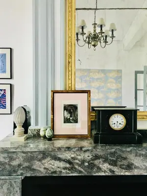 a room with a clock and a picture on a table at Le Domaine de Villespy in Villespy