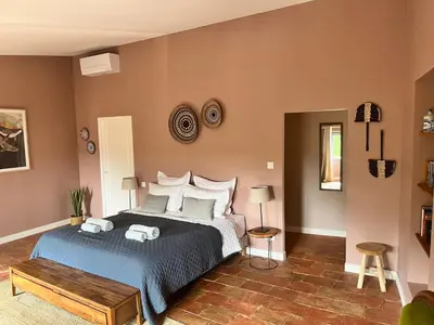 a bedroom with a bed with a blue comforter at Le Domaine de Villespy in Villespy
