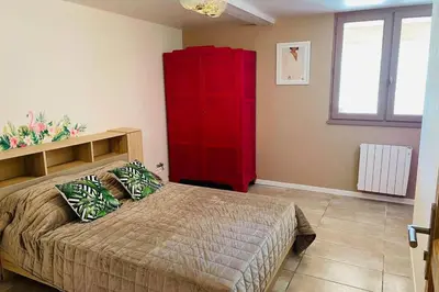 a bedroom with a red cabinet and a bed at Charmante maison avec jacuzzi in Montazels
