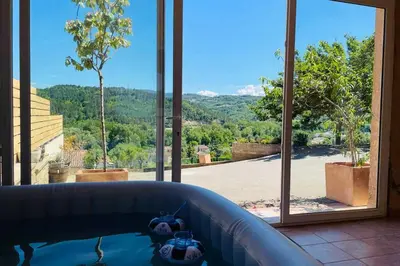 a hot tub in a room with a large window at Charmante maison avec jacuzzi in Montazels