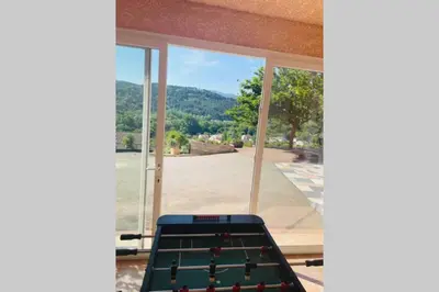 a pool table in front of a window with a view at Charmante maison avec jacuzzi in Montazels