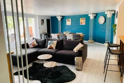 a living room with a black couch and blue walls at Charmante maison avec jacuzzi in Montazels