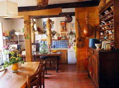 a kitchen with a wooden table and a kitchen with a counter at Chambre d'hôtes Le Rougeyras in Roquebrun