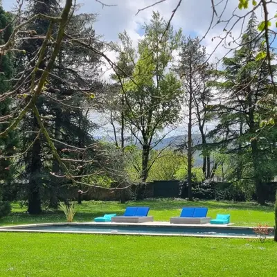 a group of blue lounge chairs in the grass at La Chapelle aux Acacias in Caucalières