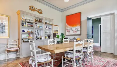a dining room with a wooden table and chairs at La Chapelle aux Acacias in Caucalières