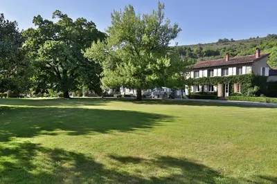 a large yard with trees in front of a house at La Chapelle aux Acacias in Caucalières