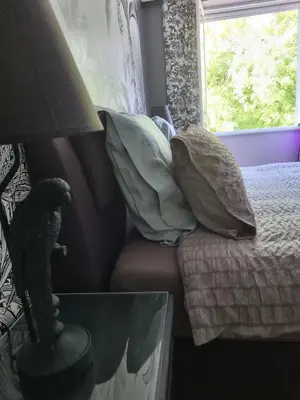 a bedroom with a bed with pillows and a window at La Chapelle aux Acacias in Caucalières