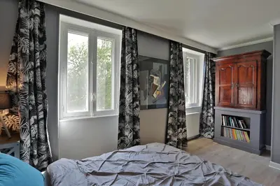 a bedroom with black and white curtains and a bed at La Chapelle aux Acacias in Caucalières