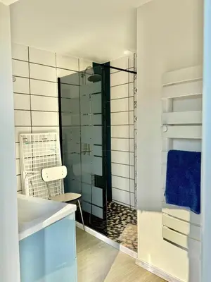 a bathroom with a glass shower with a blue towel at Maison au milieu des vignes in Aigues-Vives