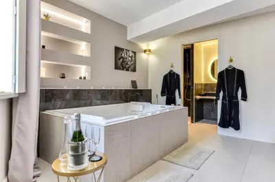 a luxury bathroom with a tub and a sink at Les Gîtes de Laure - O Lit Divin, Instant de volupté, BALNEO SAUNA, Climatisation, Netflix, 160m de la Cité Médiévale in Carcassonne