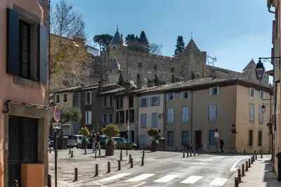 a street in a town with a castle in the background at Les Gîtes de Laure - O Lit Divin, Instant de volupté, BALNEO SAUNA, Climatisation, Netflix, 160m de la Cité Médiévale in Carcassonne