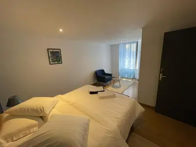 a hotel room with two beds and a chair at La pause du canal in Trèbes