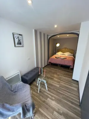 a bedroom with a bed and a couch and a table at La pause du canal in Trèbes