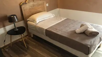 a bedroom with a bed and a table with a lamp at La pause du canal in Trèbes